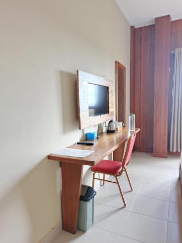 a desk with a computer and a chair in a room at Spring Hill Hotel Ruteng in Ruteng