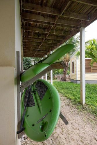 a green frisbee hanging from the side of a house at Salty Dolphin home in Governorʼs Harbour