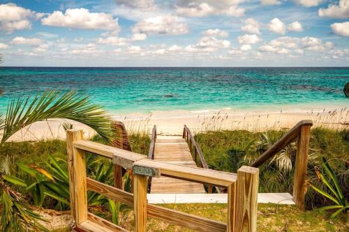 a wooden path to the beach with the ocean at Wild Orchid home in Governorʼs Harbour