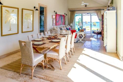 a dining room with a wooden table and chairs at Wild Orchid home in Governorʼs Harbour