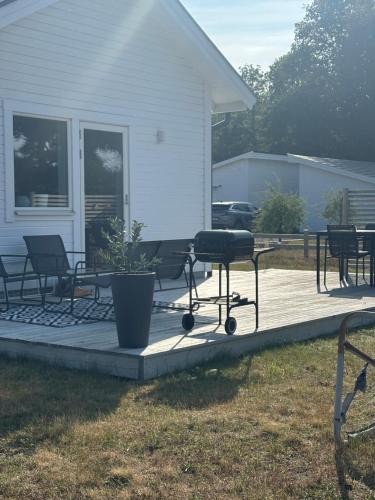 a deck with chairs and a grill on a house at Köpingsvik Holiday Home in Köpingsvik