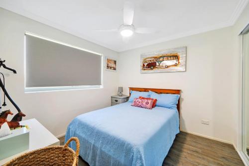a bedroom with a bed and a desk and a window at Unit 37 Dwell in Bargara