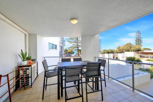 a dining room with a table and chairs on a balcony at Unit 37 Dwell in Bargara