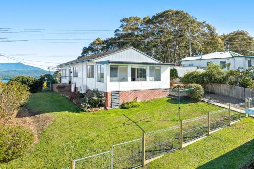 an image of a house with a yard at Nestle In Narooma - 10 Hillcrest Ave North Narooma in Kianga