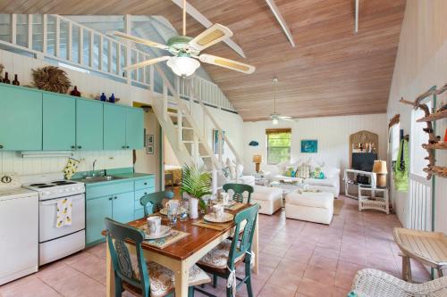 une cuisine et un salon avec une table et des chaises dans l'établissement Orchid Cottage cottage, à Governorʼs Harbour