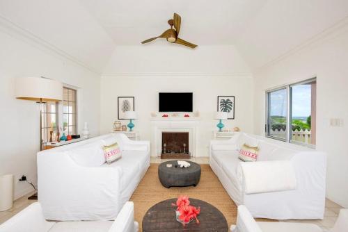 a living room with white furniture and a fireplace at Palm Hill House home in Rock Sound