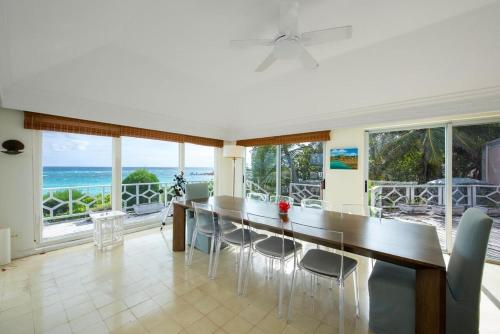 a dining room with a table and chairs and the ocean at Palm Hill House home in Rock Sound