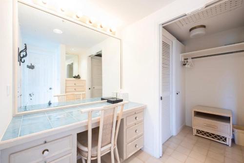 a bathroom with a vanity with a large mirror at Palm Hill House home in Rock Sound