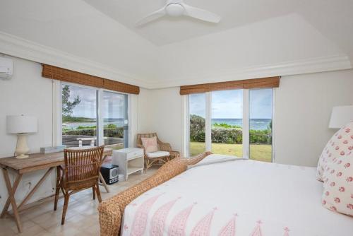 a bedroom with a bed and a view of the ocean at Palm Hill House home in Rock Sound