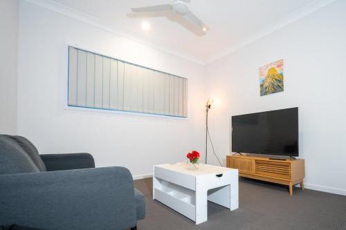 a living room with a couch and a flat screen tv at Brand New 4BR Family Oasis Easy Brisbane Access in Park Ridge
