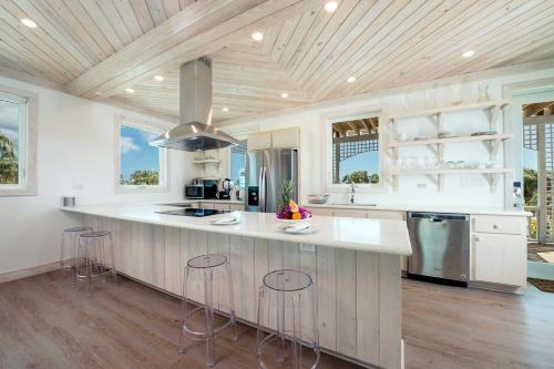 a kitchen with a large island with bar stools at See Sea home in Governorʼs Harbour