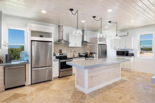 a kitchen with stainless steel appliances and white cabinets at Buttonwood Reserve Main Lodge home in James Cistern
