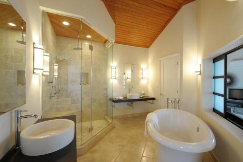 a bathroom with two sinks and a tub and a shower at Sky Beach Club Bungalow 2 cabin in Governorʼs Harbour