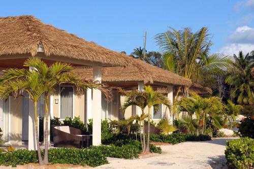 a house with palm trees in front of it at Sky Beach Club Bungalow 2 cabin in Governorʼs Harbour