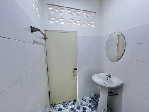 a white bathroom with a sink and a mirror at Bangsaphan Resort in Bang Saphan