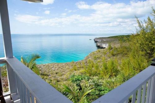 a view of the ocean from the balcony of a house at Blue Love Point 3BR home in Gregory Town