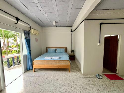 a bedroom with a bed and a large window at Bangsaphan Resort in Bang Saphan