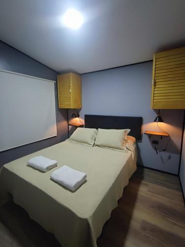 a bedroom with a bed with two towels on it at Cabañas Saiko in Futaleufú