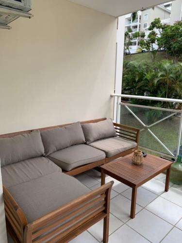 a couch and a coffee table on a balcony at Évasion Urbaine T2 Cozy et Paisible in Quartier Châteauboeuf