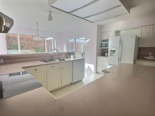 a large kitchen with white cabinets and a counter top at Vineyard Vacation Home Hot Tub Sunroom in Keremeos