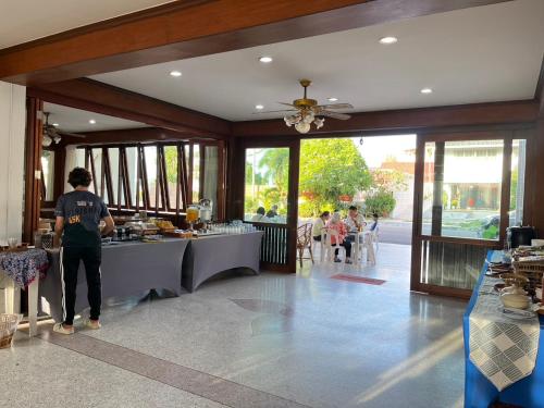 a person standing in a room with a table with food at Bangsaphan Resort in Bang Saphan