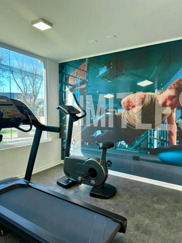 a room with a gym with a man on a treadmill at Luminoso y central dpto in Los Ángeles