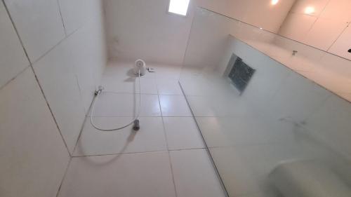 a white bathroom with a shower and a sink at Apart 202 smartTV WIFI AC 100M Cariri Shop in Juazeiro do Norte