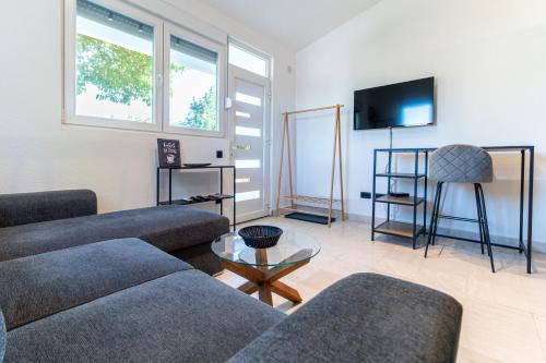 a living room with two couches and a flat screen tv at Lake and Sea Apartments with FREE Parking in Virpazar