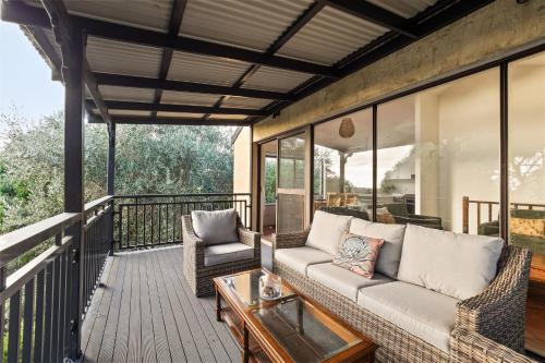 a screened in porch with a couch and a table at Little Freycinet - NEW in Gnarabup