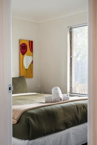 a white bedroom with a bed with a window at Little Freycinet - NEW in Gnarabup