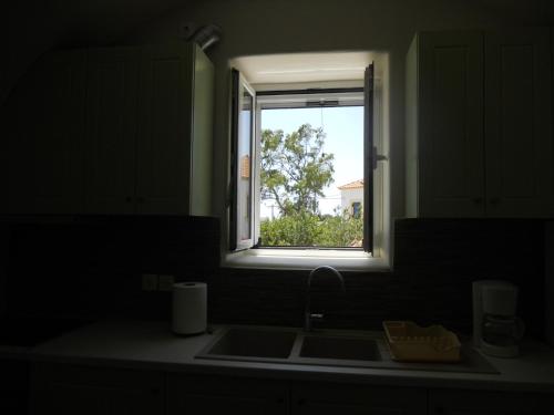 encimera de cocina con fregadero y ventana en Maira Arch House, en Potamós