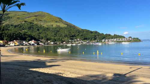 a beach with a small boat in the water at GUEST HOUSE Floresta Mar in Angra dos Reis