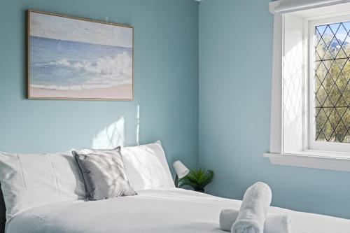 a white bed in a blue room with a window at Boutique Double Room Near Light Rail in North Parramatta - Shared Bathroom in Sydney