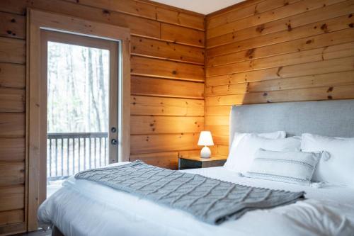a bedroom with a white bed and a window at Aska's Cozy Corner Cabin in Cherry Log