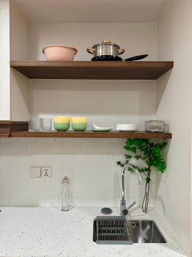 a kitchen counter with a sink and bowls on a shelf at Ly Lakeside House Tay Ho Ha Noi in Hanoi