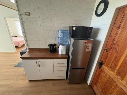 a kitchen with a refrigerator and a coffee maker on a counter at Apasibles Cabañas Quisco Norte in El Quisco