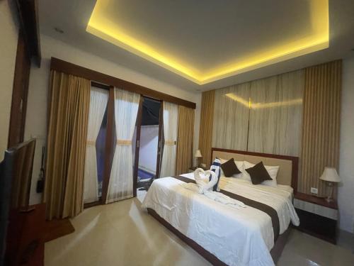 a bedroom with a large bed with white sheets at SONGOKU HOUSE APARTMEN in Pesanggaran
