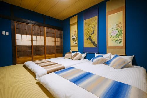 two beds in a room with blue walls at 金柑和屋 in Osaka