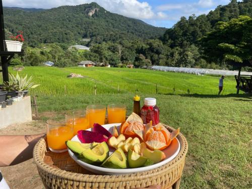 a plate of fruit and drinks in a basket at บ้านพักเคียงนา in Ban Sop Mae Klang