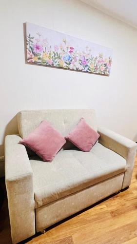 a couch with two pink pillows in a living room at Pacific Apartamento Surco in Lima
