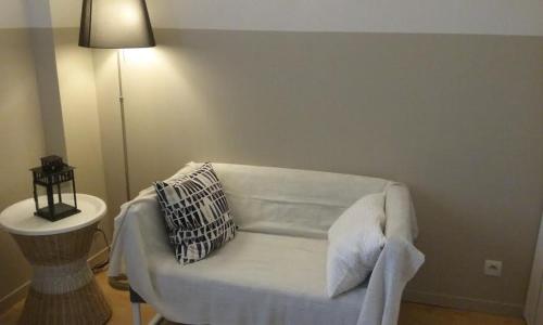 a white couch in a living room with a lamp at Residences De Chartres in Chartres