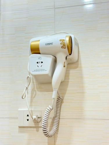 a white phone is hanging on a wall at Khách sạn HTC REGINA TUẦN CHÂU in Ha Long