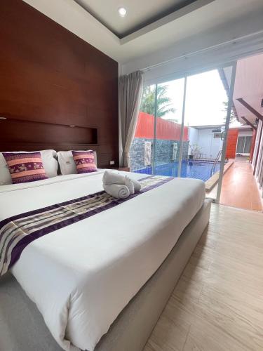 a large bed in a bedroom with a large window at The Sun Pool Villa in Chaweng