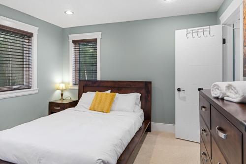a bedroom with a bed and a dresser and windows at Hearthside Estate in Prince George