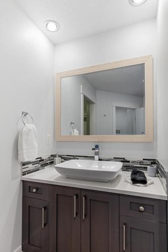 a bathroom with a sink and a large mirror at Hearthside Estate in Prince George