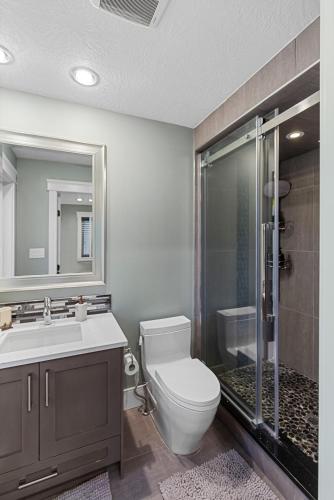 a bathroom with a toilet and a sink and a shower at Hearthside Estate in Prince George