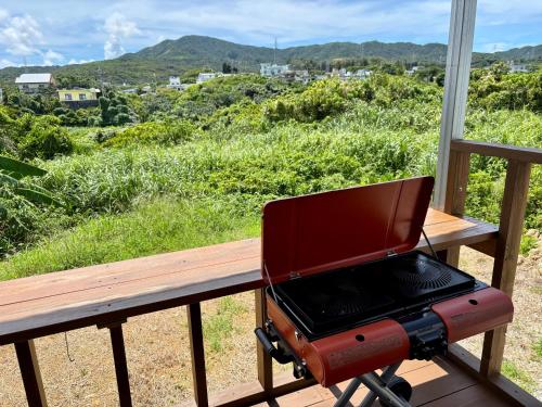 a barbecue grill sitting on a porch with a view at CondoYumangi in Onna