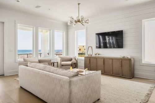 a living room with a couch and a tv at Miramare - Beachfront Luxury with Pool & Elevator in Orange Beach