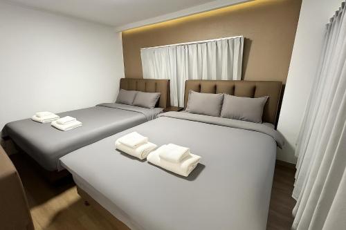 two beds in a room with white towels on them at Lucky NAMBA MINAMI in Osaka