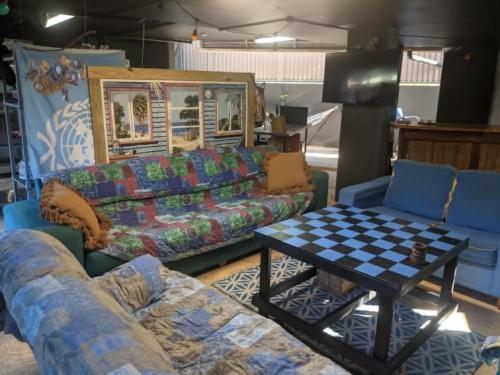 a living room with two couches and a table at 1770 Beachside Backpacker in Agnes Water